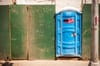 A porta potty installed along the side of a construction site